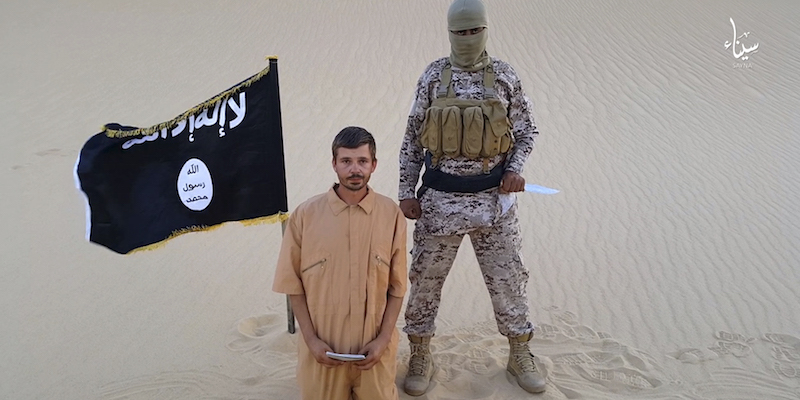 Un'immagine del video diffuso dalla Provincia del Sinai che mostra Tomislav Salopek con alle spalle un miliziano col volto coperto. (Militant website via AP)