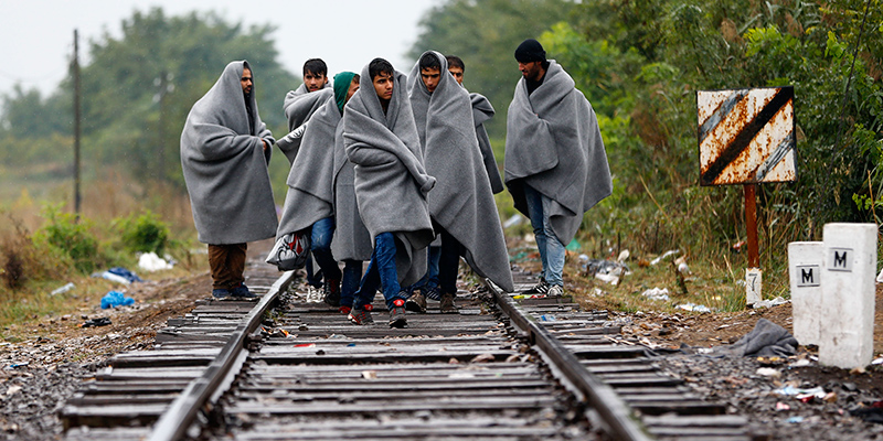 Migranti in marcia sui binari poco oltre il confine tra Serbia e Ungheria (AP Photo/Matthias Schrader)