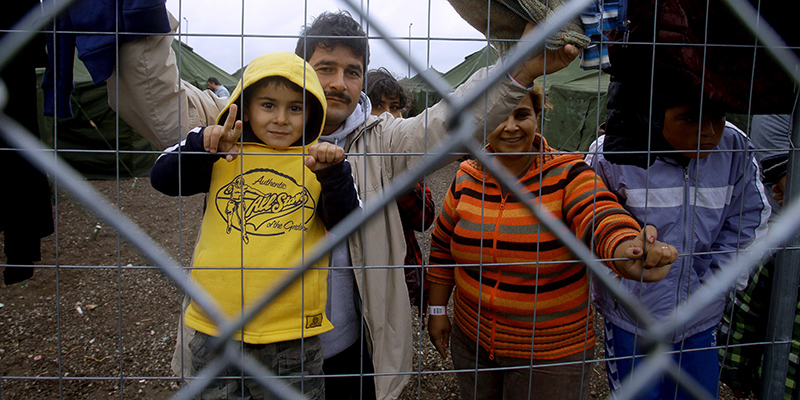 Migranti in attesa dietro una rete di un campo di accoglienza a Röszke, Ungheria (AFP PHOTO / PETER KOHALMI)