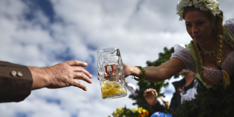 Una cameriera allunga un boccale di birra a un uomo durante la sfilata inaugurale dell'Oktoberfest, a Monaco di Baviera. (Philipp Guelland/Getty Images)