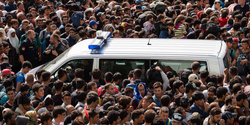 Una folla di migranti in attesa degli autobus al confine tra Austria e Ungheria, vicino Heiligenkreuz. (AP Photo/Christian Bruna)