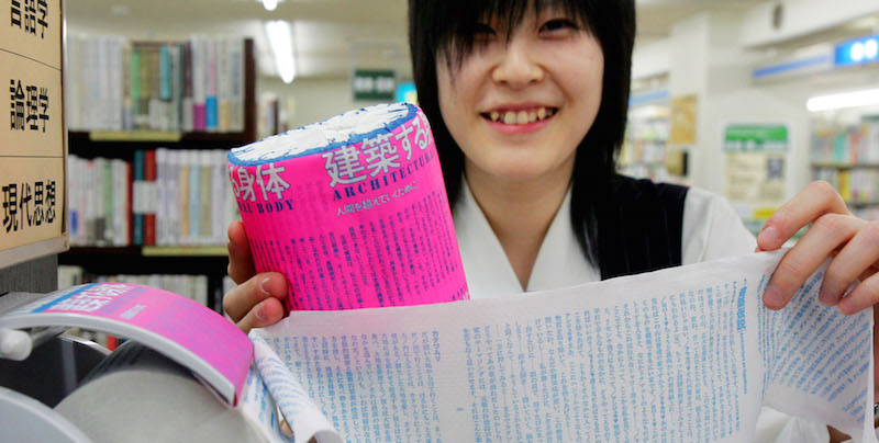 Una dipendente della libreria Sanseido Book Store Ltd. di Tokyo mostra un rotolo di carta igienica in vendita nel negozio sui cui fogli è stato stampato un libro di filosofia. (AP Photo/Koji Sasahara)