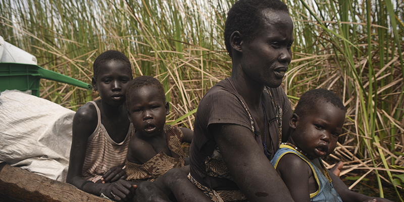 Una donna e i suoi figli su una canoa, in fuga attraverso una palude dal conflitto in Sud Sudan, 11 ottobre 2015 (AP Photo/Jason Patinkin)
