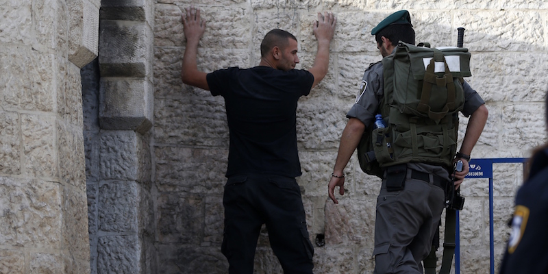 Un poliziotto israeliano perquisisce un ragazzo palestinese a un'entrata della città vecchia a Gerusalemme est, il 13 ottobre 2015. (AHMAD GHARABLI/AFP/Getty Images)