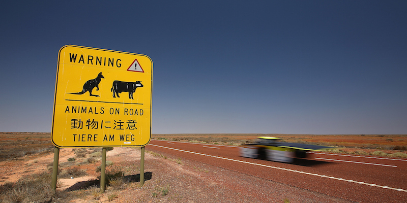 La macchina della squadra australiana Clenergy TeamArrow passa davanti a un cartello a Coober Pedy, Australia, 21 ottobre 2015 (Mark Kolbe/Getty Images for The World Solar Challange)