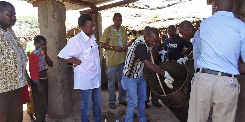 I funzionari del ministero della Salute del Mozambico prelevano dei campioni dal contenitore in cui è stata prodotta a birra che ha causato la morte di 75 persone, 12 gennaio 2015 (AP Photo/Antonio Chimundo)