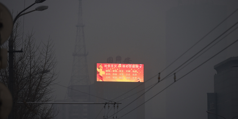 Un tabellone di propaganda del partito comunista cinese spicca nel cielo inquinato di Pechino, 27 novembre 2015. 
(GREG BAKER/AFP/Getty Images)