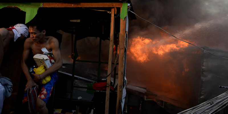 Un uomo raccoglie le sue cose e scappa dalla zona di Mandaluyong colpita dall'incendio. (NOEL CELIS/AFP/Getty Images)