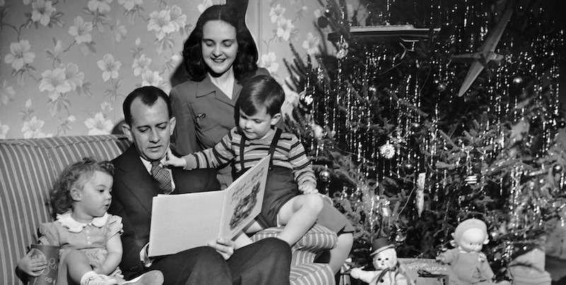 Una famiglia legge davanti all'albero di Natale, negli anni Cinquanta. 
(George Marks/Retrofile/Getty Images)