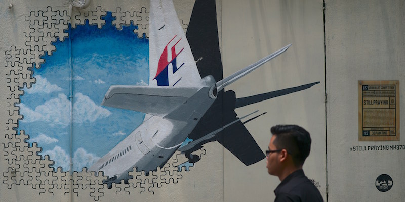 Un uomo cammina davanti a un murale in ricordo del volo MH370 a Kuala Lumpur. (MOHD RASFAN/AFP/Getty Images)