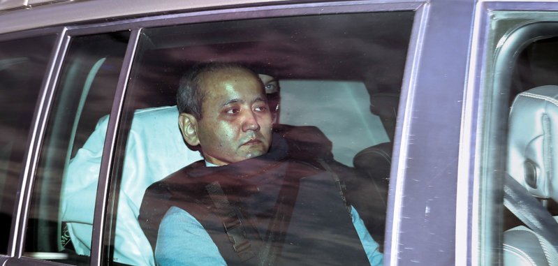 Mukhtar Ablyazov viene scortato dalla polizia al tribunale di Lione, il 17 ottobre 2014. (PHILIPPE MERLE/AFP/Getty Images)