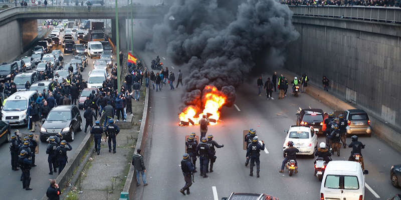 L'arrivo della polizia durante una manifestazione dei taxisti sulla tangenziale nella zona di porte Maillot a Parigi
(THOMAS SAMSON/AFP/Getty Images)