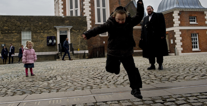 Un bambino salta oltre la riga che segna il passaggio del meridiano di Greenwich a Londra (ADRIAN DENNIS/AFP/Getty Images)