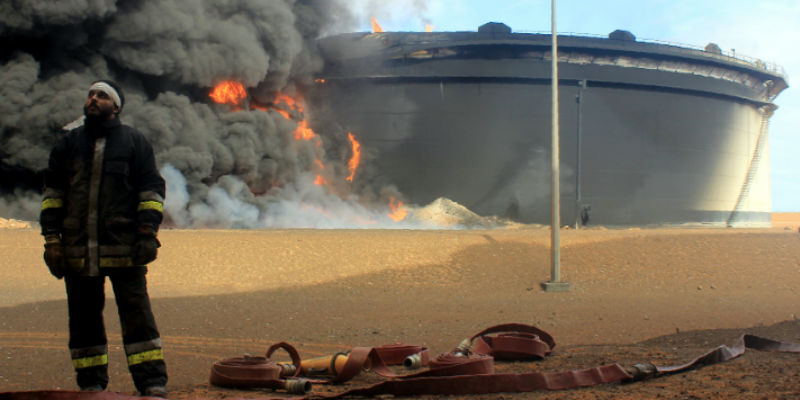 Un pompiere libico di fronte a una cisterna petrolifera in fiamme nell'area di Ras Lanuf il 23 gennaio 2016, dopo un attacco dell'Isis (STRINGER/AFP/Getty Images)