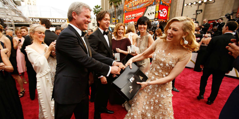 Cate Blanchett fa finta di strappare a Brian Cullinan la valigetta con i risultati degli Oscar al Dolby Theater di Los Angeles, il 2 marzo 2014 (Al Seib/LA Times via Getty Images)