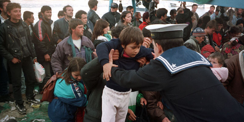 Un marinaio afferra un bambino all'arrivo di un “barcone” con a bordo profughi albanesi del porto di Brindisi, 17 marzo 1997 (C.Ferraro / ANSA)
