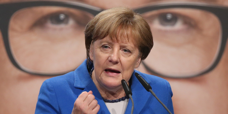 Angela Merkel durante un evento di campagna elettorale nello stato tedesco di Baden-Württemberg, con dietro un manifesto del principale candidato locale del suo partito, Guido Wolf (Sean Gallup/Getty Images)
