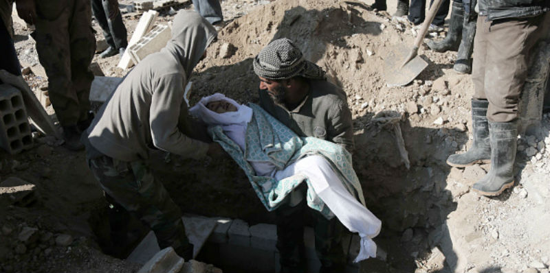 Un uomo seppellisce la figlia nel villaggio di Deir al-Asafir, fuori Damasco (AMER ALMOHIBANY/AFP/Getty Images)