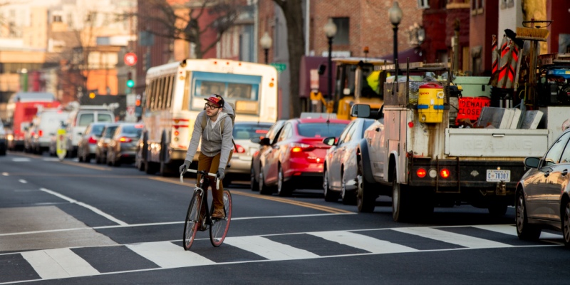 Un ciclista passa accanto alle auto in coda in Florida Avenue, a Washington. (AP Photo/Andrew Harnik)