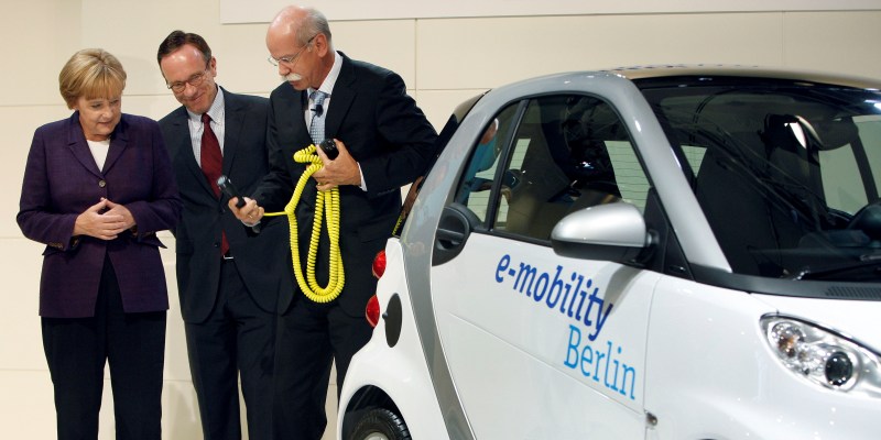 Il Cancelliere tedesco Angela Merkel, sinistra, e il CEO Daimler Dieter Zetsche, destra, accanto a una Smart elettrica. (AP Photo/Michael Sohn)