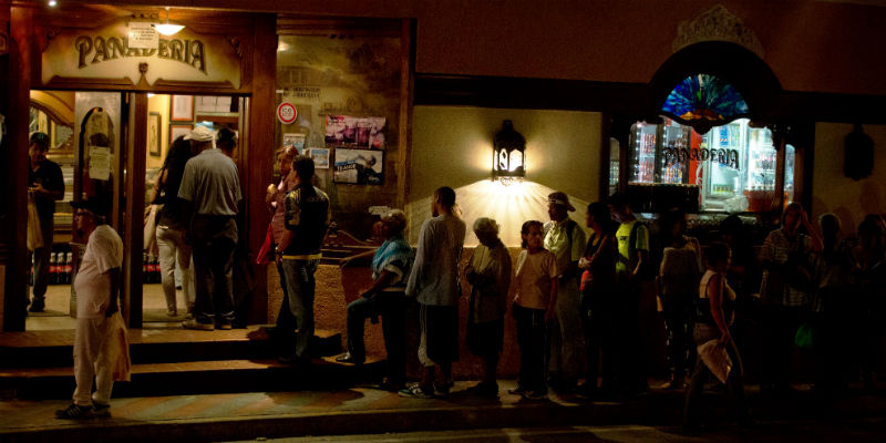 Persone in fila per acquistare il pane in un sobborgo della capitale Caracas (AP Photo/Fernando Llano)
