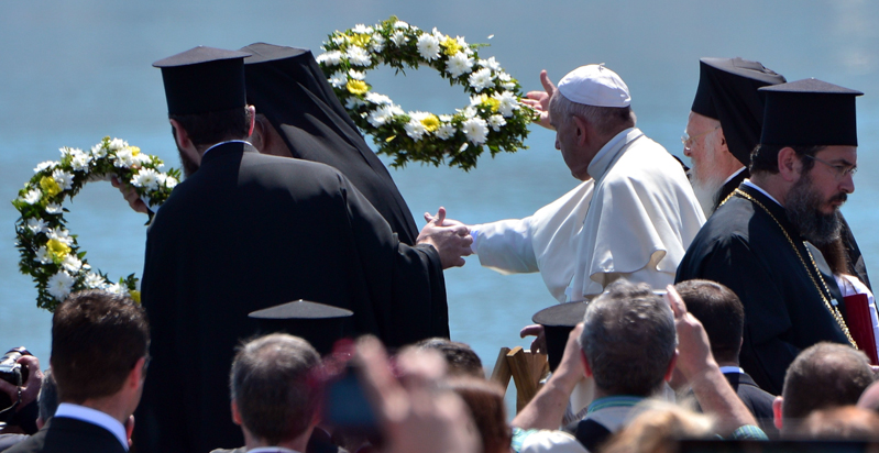 Papa Francesco e il Patriarca di Costantinopoli gettano delle corone di fiori in mare in memoria dei migranti morti nel tentativo di raggiungere l'isola di Lesbo. dox Patriarch Barthol(LOUISA GOULIAMAKI/AFP/Getty Images)