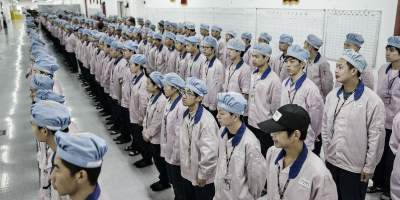 Gli operai della fabbrica di Pegatron, fuori Shanghai, che produce iPhone per Apple (Qilai Shen/Bloomberg)