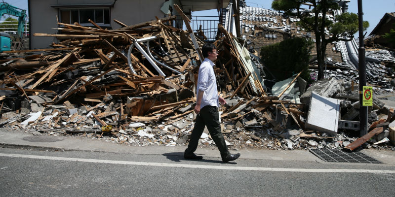 Un uomo cammina vicino a una casa crollata a Mashiki, vicino a Kunamato, l'epicentro del terremoto del 14 aprile (Carl Court/Getty Images)