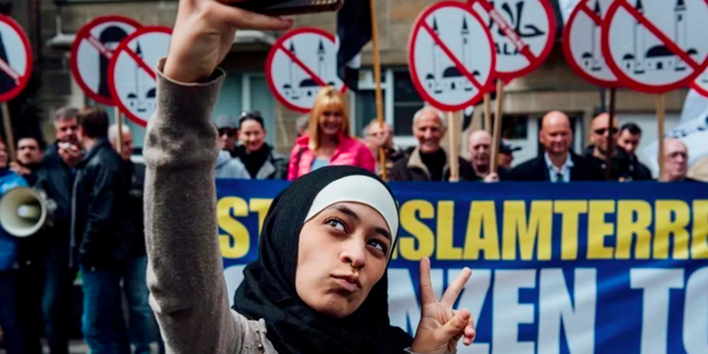 La foto di Zakia Belkhiri, mentre si fa un selfie davanti a dei manifestanti anti-islamici (Jurgen Augusteyns)