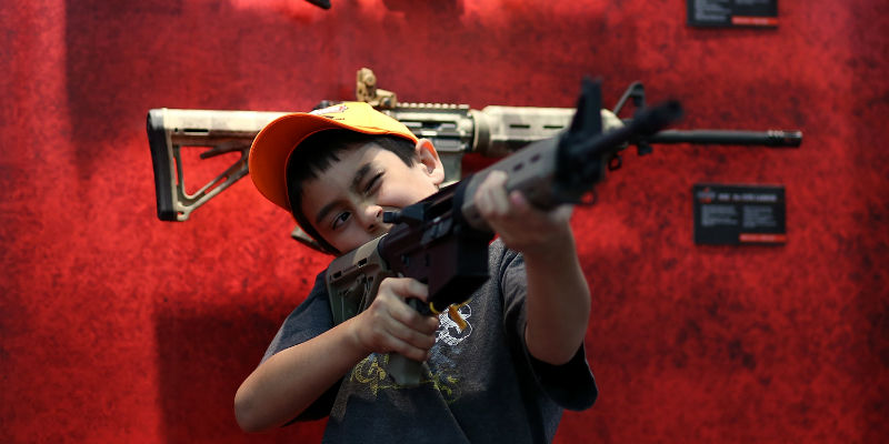 Un bambino con un fucile d'assalto durante il convegno annuale della National Rifle Association del 2013, a Houston, Texas (Justin Sullivan/Getty Images)