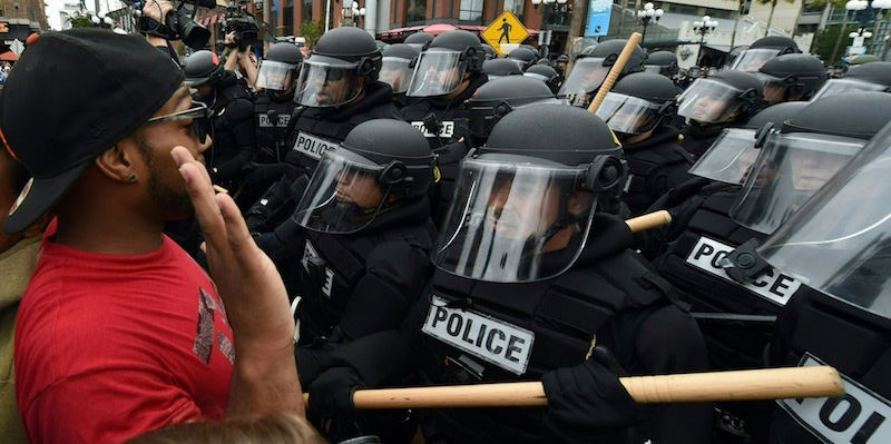 Un partecipante a un corteo anti Trump parla con un gruppo di poliziotti a San Diego, 27 maggio 2016 (MARK RALSTON/AFP/Getty Images)