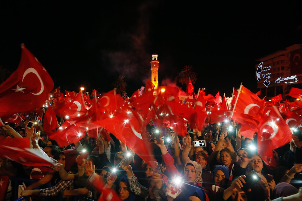 Un gruppo di cittadini turchi sventola bandiere della Turchia durante una manifestazione filogovernativa in Konak Meydanı (piazza Meydani) (Evren Atalay / Anadolu Agency)