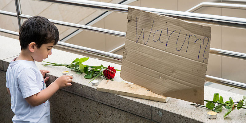 Un bambino con una candela per ricordare i morti della sparatoria di Monaco fuori dal centro commerciale OEZ, il 23 luglio 2016 (Joerg Koch/Getty Images)