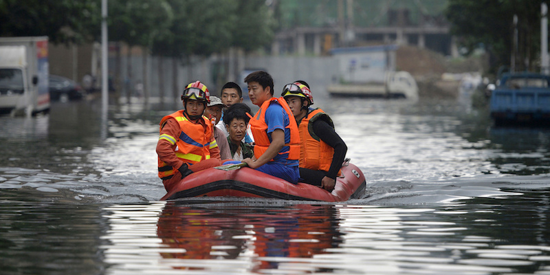 Alcuni soccorritori in gommone su una strada allagata di Shenyang, nel nordest della Cina, 21 luglio 2016 (Chinatopix via AP)