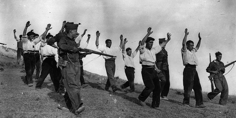 Un soldato delle truppe nazionaliste e alcuni repubblicani catturati da poco, nel novembre 1936 (Keystone/Getty Images)