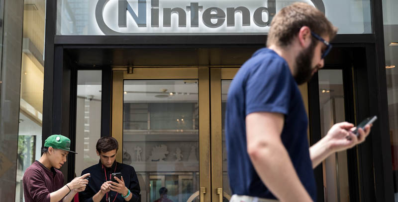 Tre ragazzi giocano a Pokémon Go davanti a un negozio Nintendo a New York. (Drew Angerer/Getty Images)