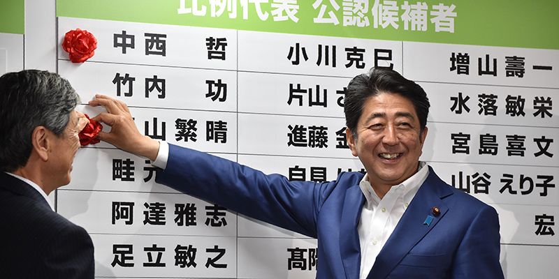 Il primo ministro Shinzo Abe davanti a un tabellone per segnare i risultati elettorali - Tokyo, Giappone (KAZUHIRO NOGI/AFP/Getty Images)
