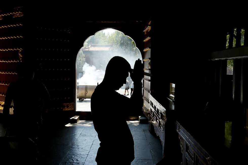 Un uomo prega al monastero buddista del Yonghe Gong. La foto è stata scattata il 19 agosto. (STR/AFP/Getty Images)