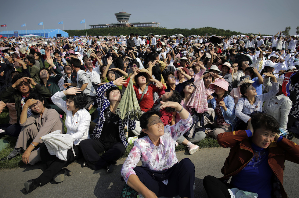 Un gruppo di nordcoreani assiste a uno spettacolo aereo nell'ambito delle celebrazioni per la ristrutturazione dell'aeroporto commerciale di Wonsan (Photo/Wong Maye-E)