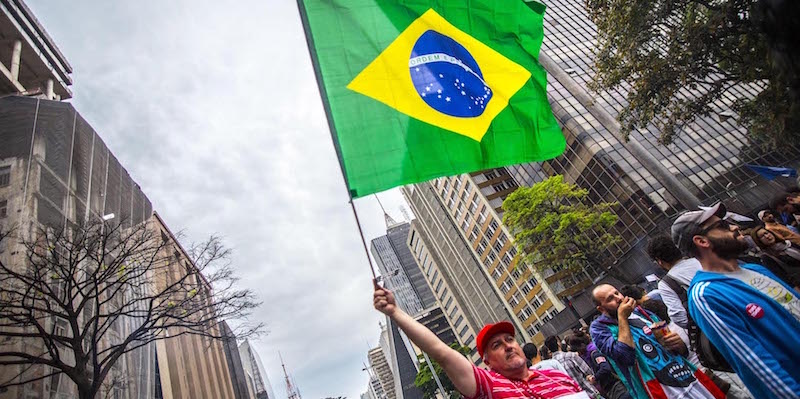 Un uomo tiene in mano una bandiera brasiliana durante la manifestazione di protesta contro l'impeachment di Dilma Rousseff a San Paolo, 4 settembre 2016 (Cris Faga via ZUMA Wire)