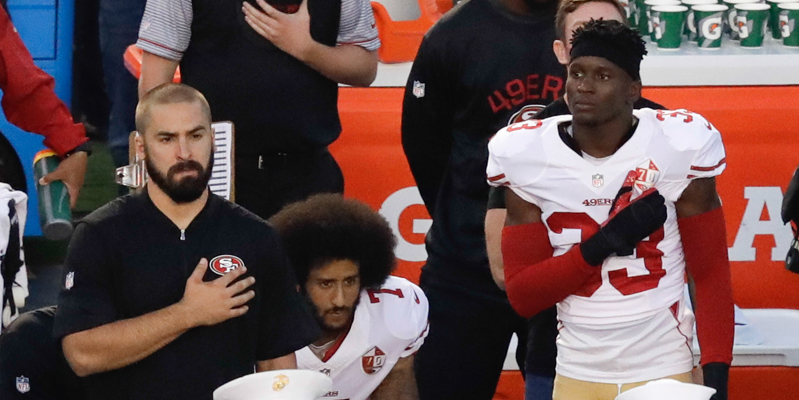 Colin Kaepernick dei San Francisco 49ers mentre sta seduto durante l'inno americano, prima di una partita contro i San Diego Chargers, il primo settembre 2016. (AP Photo/Chris Carlson)