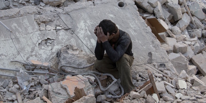 Un ragazzino seduto tra le macerie dopo un bombardamento su Aleppo (KARAM AL-MASRI/AFP/Getty Images)