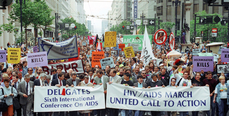 Migliaia di persone partecipano a una marcia per la Sesta conferenza sull'AIDS, organizzata per sensibilizzare sulla malattia e chiedere maggiori fondi per le persone malate, San Francisco, California, 23 giugno 1990
(AP Photo/Eric Risberg)