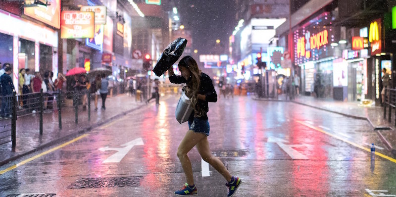 Una ragazza cammina sotto la pioggia a Hong Kong
(Alex Ogle/AFP/Getty Images)