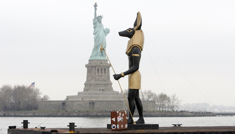 La replica di una statua del dio egiziano di Anubi e sullo sfondo la Statua della Libertà a New York
(AP Photo/Seth Wenig)