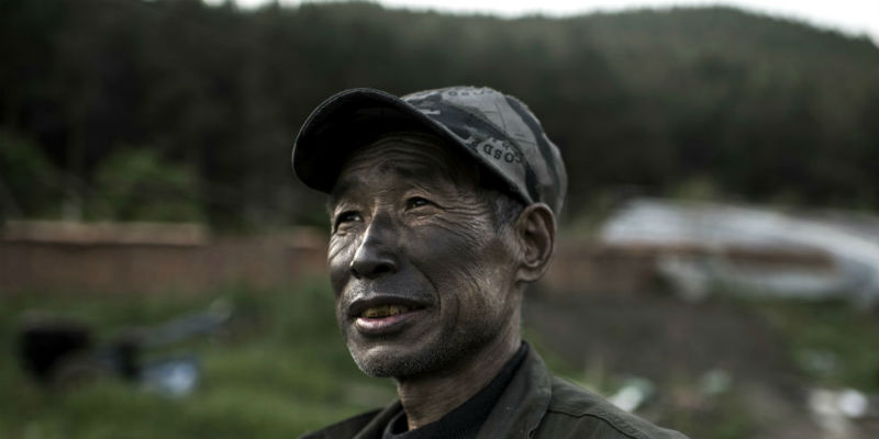 Un operaio di una fabbrica di grafite torna a casa con la faccia annerita dal minerale a Mashan, nella provincia cinese di Heilongjiang (Michael Robinson Chavez/The Washington Post)