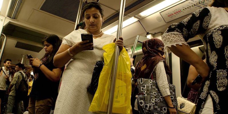 Donne indiane usano i propri smartphone in una carrozza della metropolitana di New Delhi riservata alle donne, il 3 luglio 2015 (ANNA ZIEMINSKI/AFP/Getty Images)