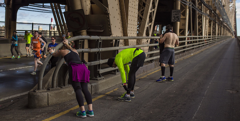 Alcuni corridori fanno stretching sul ponte Queensboro (AP Photo/Andres Kudacki)