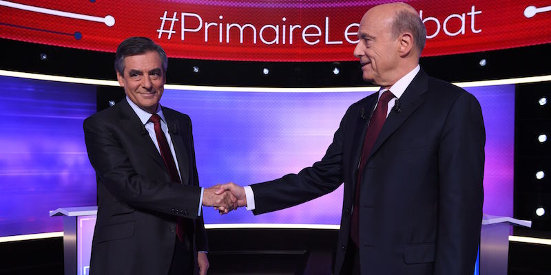 Alain Juppé, a destra, e François Fillon, a sinistra, si stringono la mano prima del loro ultimo dibattito televisivo, il 24 novembre 2017 a Parigi (ERIC FEFERBERG/AFP/Getty Images)