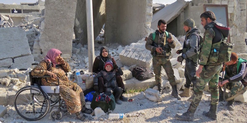 Quattro combattenti fedeli ad Assad insieme a un bambino e due donne residenti nel quartiere Sheikh Saeed di Aleppo, prima sotto il controllo dei ribelli 
(STRINGER/AFP/Getty Images)